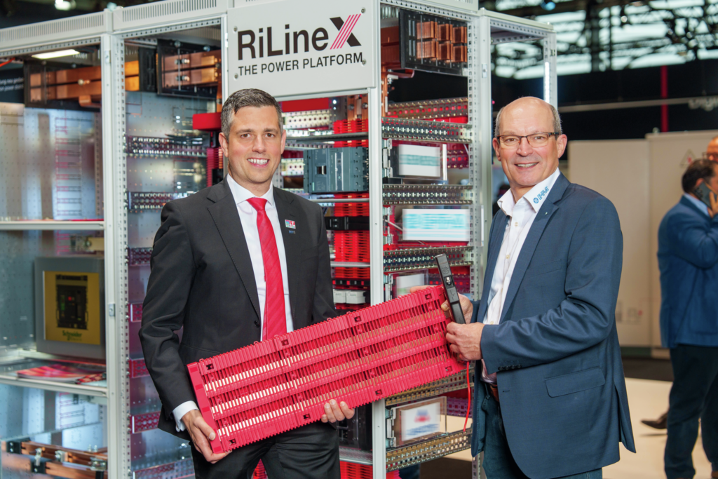 AC? DC? - Gemeinsam geht's schneller 1 Gleichstrom-Kompetenz für RiLineX: Raphael Görner (Rittal, links) und Richard Mehl (E-T-A) auf der SPS in Nürnberg bei der Vorstellung der neuen Plattform.