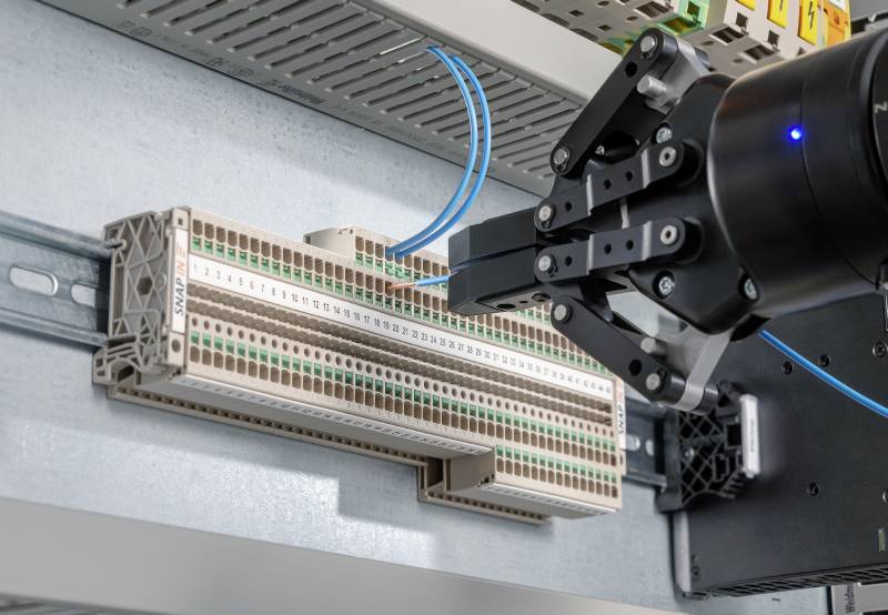 Warten auf den Klick-Moment 2 Bild 2 | Das Design der neuen Snap-In-Reihenklemmen wurde extra so konzipiert, dass die Industrieroboter diese greifen und aufrasten können.