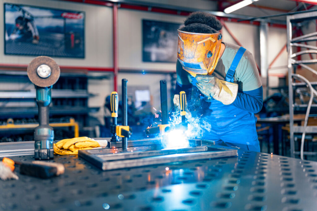 Gute wirtschaftliche Lage und Fachkräftemangel 1 A worker is using a welding machine in his hand and working on a