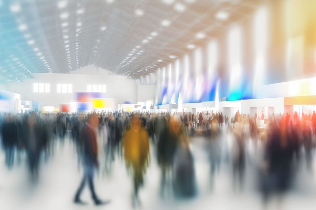 Ein Schaufenster für Industrie 4.0 1 Background of an expo with blurred individuals in an exposition hall. Concept for a major international exhibition conference center corporate marketing and event fair. Generative AI