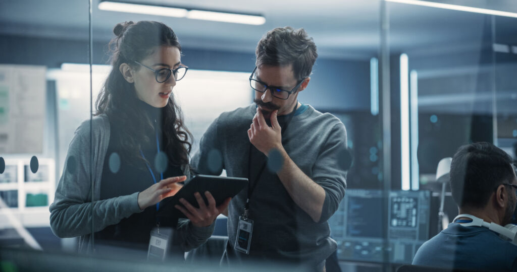 Wie wird man eigentlich CISO? 2 Portrait of Two Creative Young Female and Male Engineers Using T