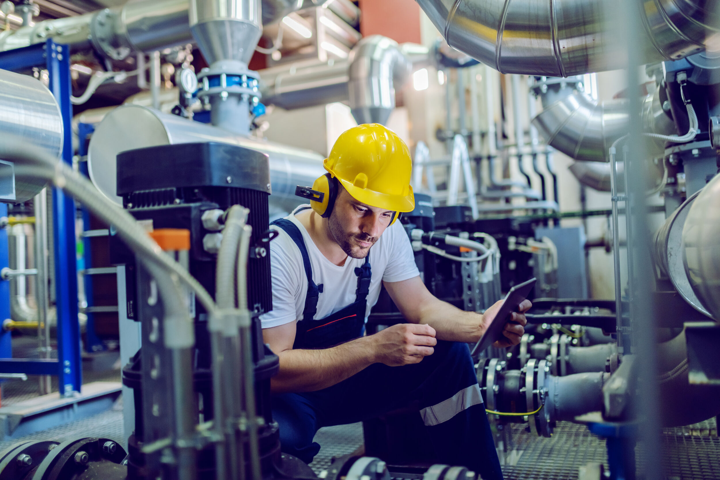 Welches Potenzial in Werkerassistenzsystemen steckt 3 Focused plant worker in overalls with protective helmet on head