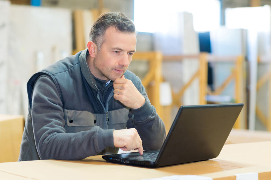 Was eine neue B2B-Einkäufer-Generation für Maschinenbauer bedeutet 1 male worker looking at laptop in workshop