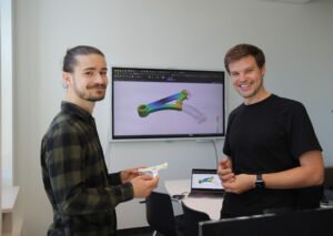 Nils Meyer (r.) und Projekt-Mitarbeiter Julian Greif entwickeln ein KI-Tool, um die Bauteilentwicklung im Spritzguss zu optimieren.