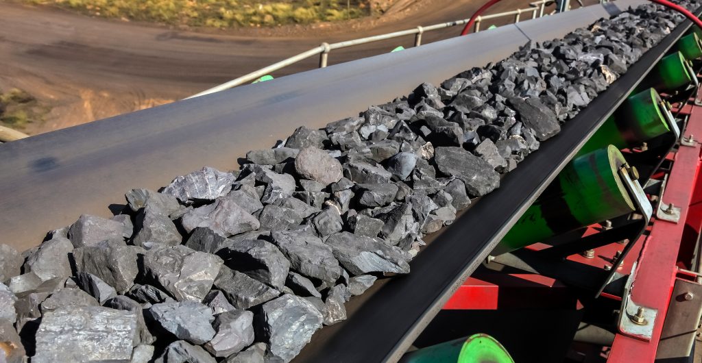 Der digitale Knoten platzt 3 Close up of Manganese rock on a conveyor belt