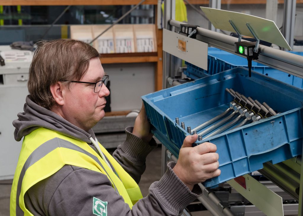 Handarbeit trifft Automatisierung 4 Die physische Barriere zu den Teilebehältern ist über intelligente Klappentüren realisiert, zeitgleich fordert ein Leuchttaster am Behälter zur Entnahme auf.