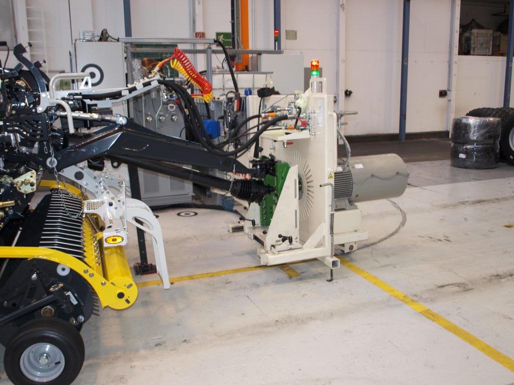 Ohne Barrieren sicher geprüft 3 Anstelle eines vorgespannten Traktors treibt die Prüfeinrichtung die Rundballenpresse mechanisch an und stellt die hydraulische Versorgung sicher.