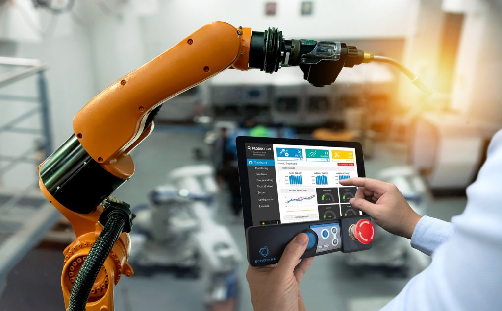 Deterministische und zuverlässige Safety-Funkkommunikation 2 Engineer hand using tablet, heavy automation robot arm machine in smart factory industrial with tablet real time monitoring system application. Industry 4th iot concept.