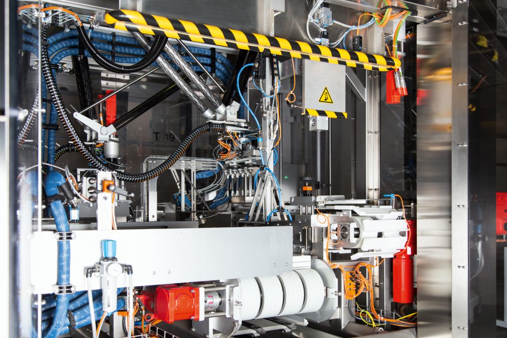 Intelligent gesteuert,
flink verpackt 4 SEW5677_Kinematik: Die Kinematik verschließt über eine spezielle Bahnkurve den Karton und setzt ihn um 90° gedreht auf das Ausschleuseband um.