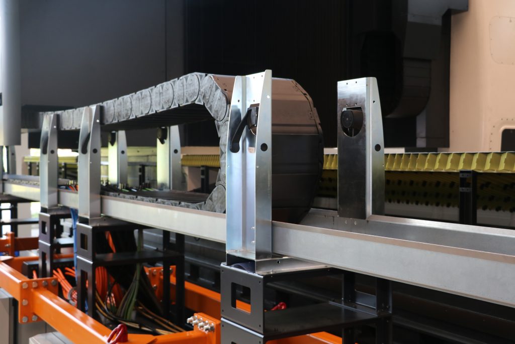 Wenn XXL-Maschinen noch größer werden 2 Die Guidelok-Rollenhalter fahren beim Vorbeifahren selbsttätig ein und aus und verhindern somit eine Berührung von Obertrum und Untertrum der Energiekette.