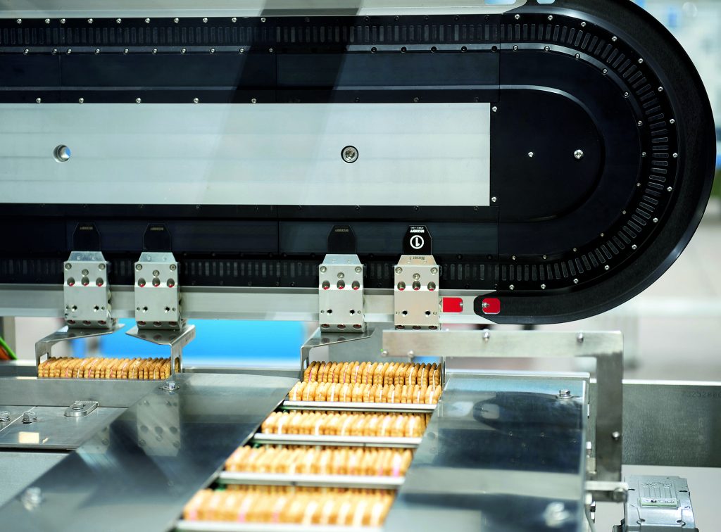 Hochflexible Keks-Zuführung 1 Die erste XTS-Anwendung von Cavanna ist ein 90°-Transfersystem für die Slug-Verpackung von Keksen.