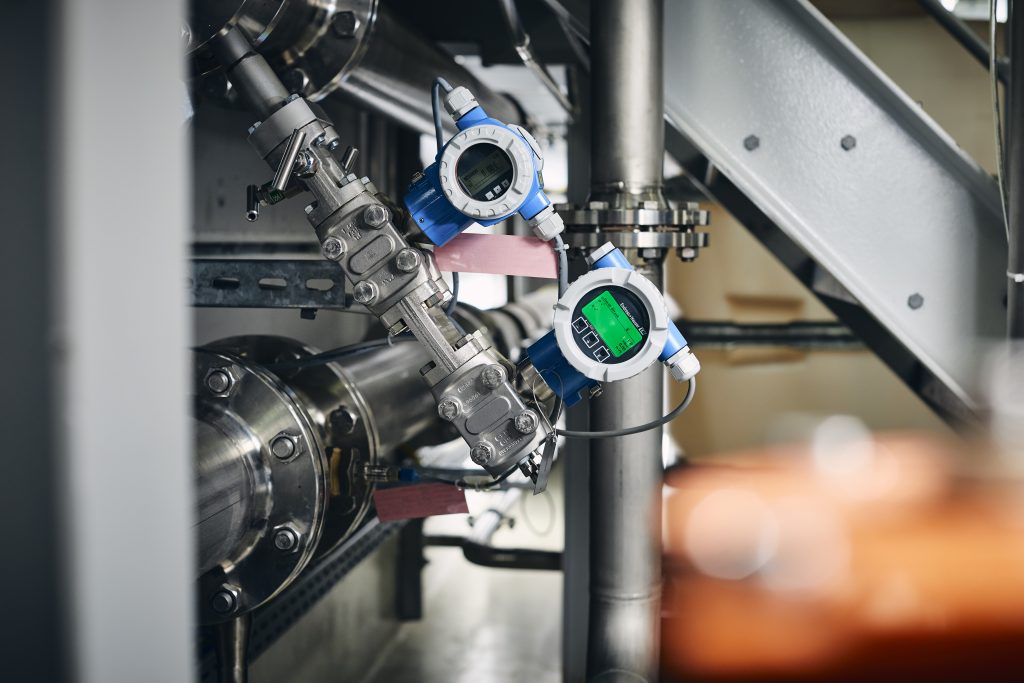 Ein Herz für Industrie 4.0 3 Ein Gerät aus der neuen Deltabar-Gerätefamilie (rechts, mit grünem Display), daneben ein Vorgängermodell.