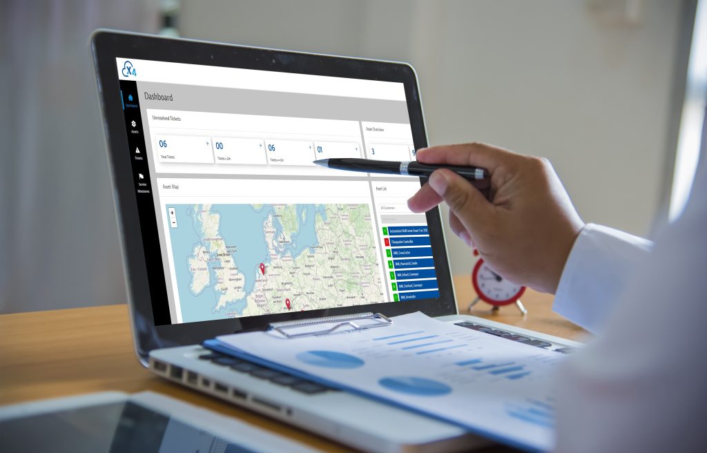 Asset- und Ticketmanagement für höhere Maschinenverfügbarkeit 1 Over the Shoulder Shot of Engineer Working with CAD Software on Desktop Computer, Screen Shows Technical Drafts and Drawings. In the Background Engineering Facility Specialising on Industrial Design
