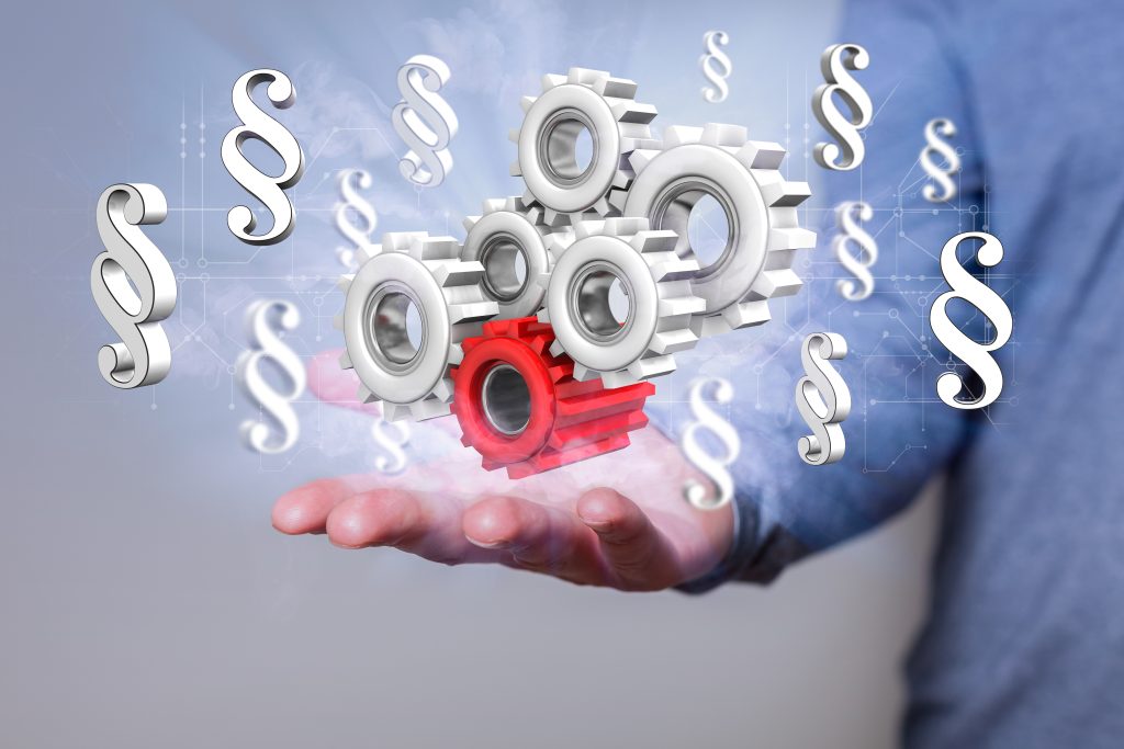 Industry Regulations hand with gear wheels and paragraphs