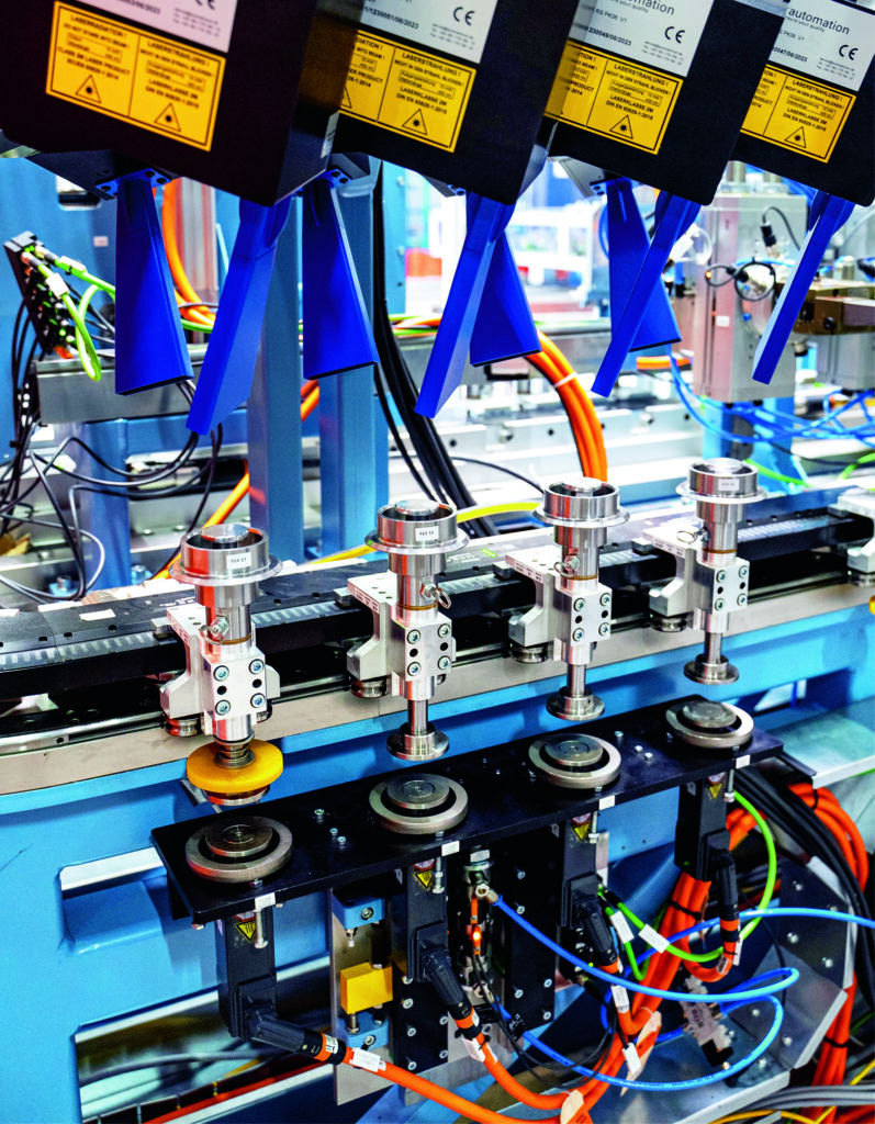 Präziser und dynamischer Materialtransport 2 Die mit den XTS-Movern transportierten Kegelräder werden sowohl bei der Prüfung der Innenverzahnung als auch zur Einbaudistanzklassifizierung über Servomotoren AM8000 (unten) angehoben.