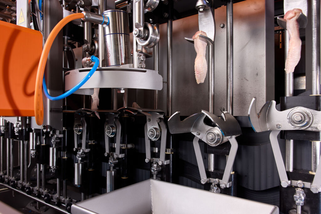 Geflügel präzise portioniert 1 Durch die Kombination von KI-gestützter Vision-Technologie mit fortschrittlicher Bewegungssteuerung ist die Anlage Smartwing in der Lage bis zu 8.000 Hähnchenflügel pro Stunde auf den mm genau zu portionieren.