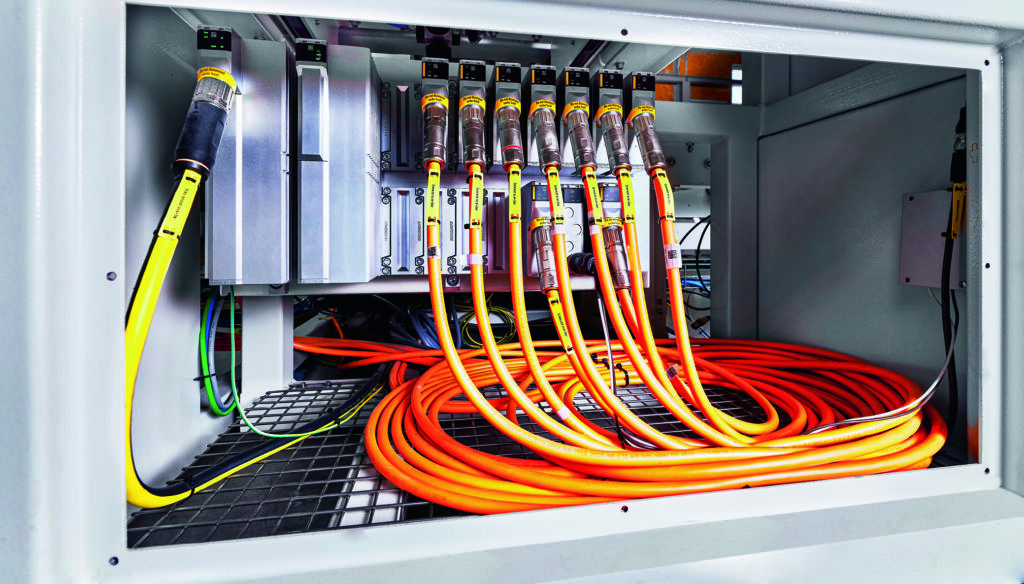 Platzsparen beim Retrofit 1 Das MX-System im unteren Teil der Maschine sorgt unter anderem für einen reibungslosen Transport der mit Pulverlack gefüllten Kartons durch die Anlage.