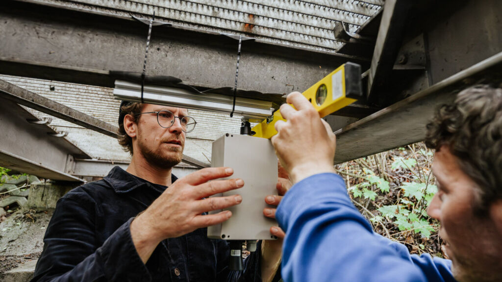 Das Team bringt einen weiteren Sensor unter einer Brücke an.