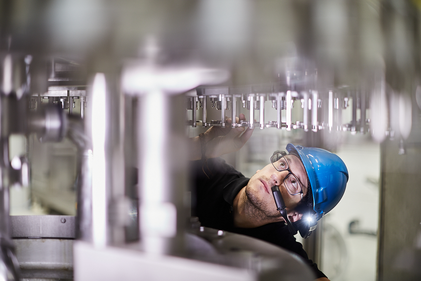 Ein Mitarbeiter von Krones inspiziert die Flaschenabfüllanlage.