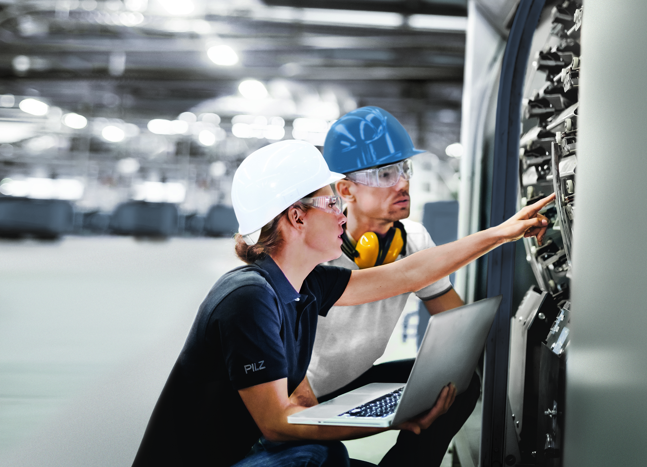 Two engineers with laptop checking machine