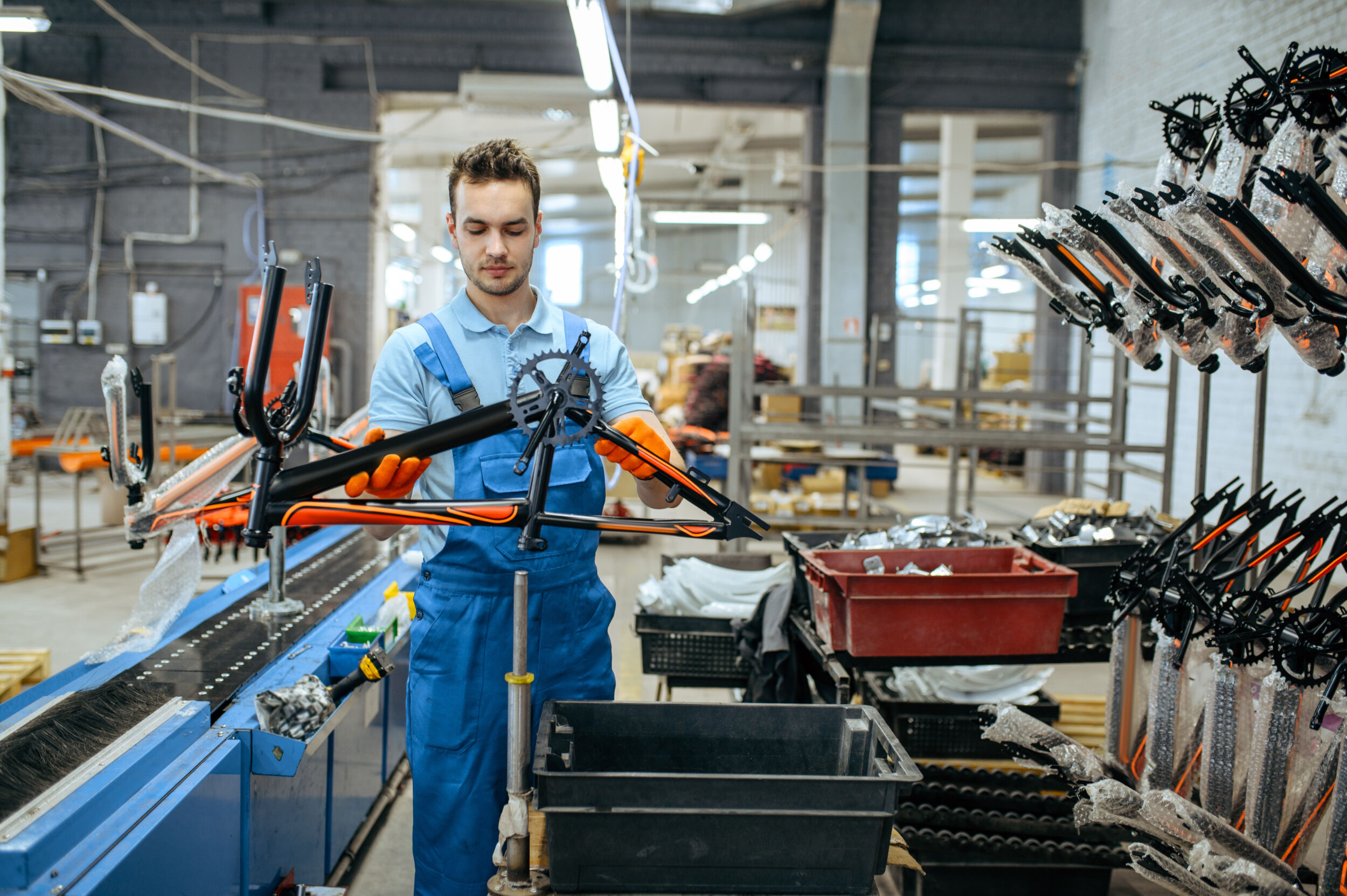 Bicycle factory worker holds teen bike frame